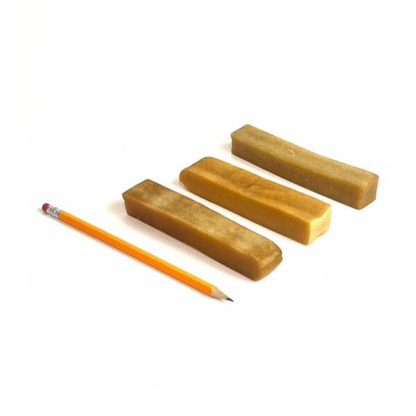 Large yak chews next to pencil